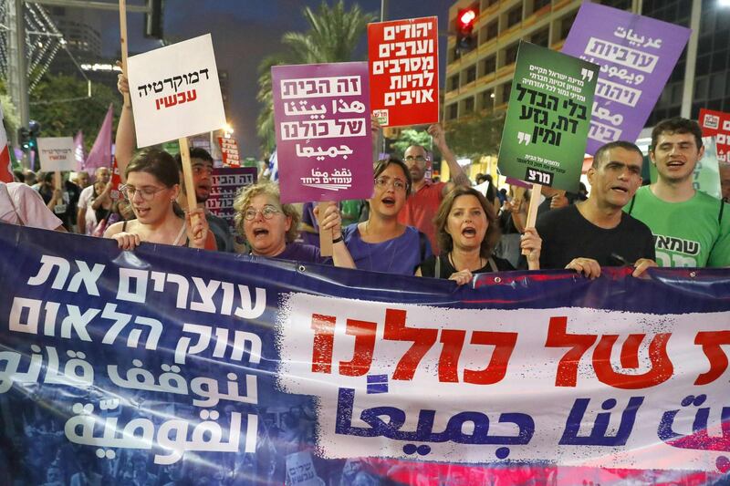 Demonstrators attend a rally to protest against the 'Jewish Nation-State Bill' in the Israeli coastal city of Tel Aviv on July 14, 2018. The Jewish Nation-State Bill is a draft Basic Law with constitutional weight that declares that Israel is the nation-state of the Jewish people. / AFP / JACK GUEZ
