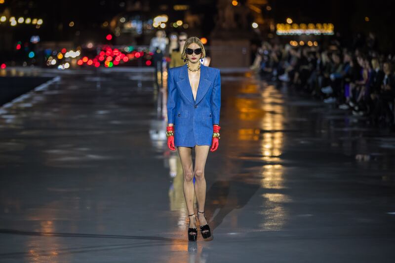 A model presents a creation from the Spring/Summer 2022 Ready to Wear collection by Saint Laurent fashion house in front of the Eiffel Tower during the Paris Fashion Week, in Paris, France, 28 September 2021.  The presentation of the Women's collections runs from 27 September to 05 October.   EPA / CHRISTOPHE PETIT TESSON