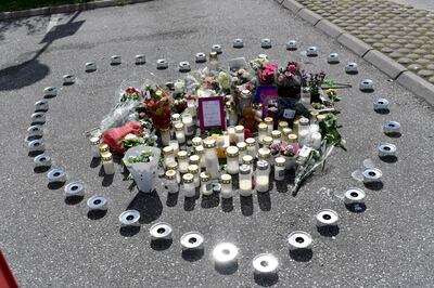epa08581882 Flowers and candles in the shape of a heart where a twelve-year old girl was shot dead early 02 August 2020, at a motorway service area in Botkyrka, south of  Stockholm, Sweden, 03 August 2020. According to unconfirmed reports the teenage girl was hit by a stray bullet and had not been the intended target.  EPA/STINA STJERNKVIST  SWEDEN OUT
