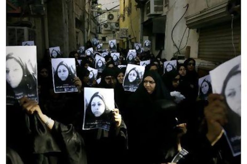 Women attending the funeral of Bahiya al Aradi hold up her portrait. She went missing on March 16 and her car was found the day after with bloodstains on the driver's seat. She was pronounced dead on March 21 after being shot in the head.