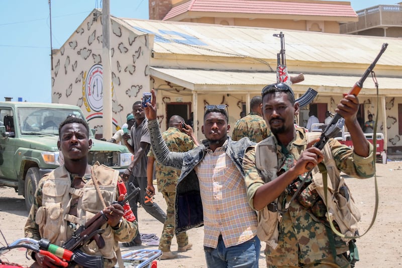 Sudanese army soldiers, loyal to army chief Gen Abdel Fattah Al Burhan, pose for a picture at the Rapid Support Forces base in the Red Sea city of Port Sudan on April 16. AFP