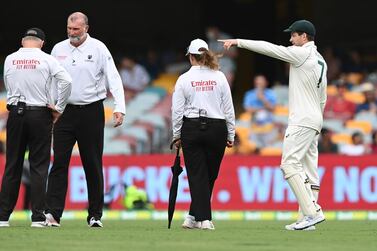 Australia captain Tim Paine speaks to the umpires during the rain delay on day two of the fourth Test Match against India at The Gabba. Getty Images