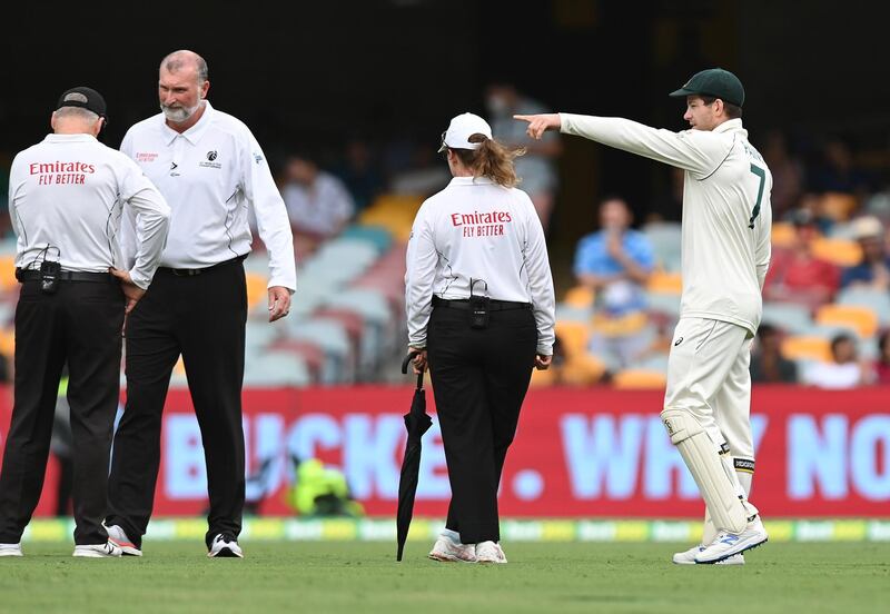 BRISBANE, AUSTRALIA - JANUARY 16: Tim Paine of Australia speaks to the umpires during the rain delay during day two of the 4th Test Match in the series between Australia and India at The Gabba on January 16, 2021 in Brisbane, Australia. (Photo by Bradley Kanaris/Getty Images)