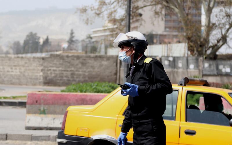 epa08319353 A policeman wearing face mask walks in Damascus, Syria, 24 March 2020. Syrian government introduced measures to prevent the spread of the coronavirus after Syria announced the first case of covid19 on 21 March. Syria imposed a curfew from 6pm to 6am local time as of 24 March, suspended work in the ministries and its affiliated entities until further notice and closed markets and suspend all commercial, service, cultural and social activities.  EPA/YOUSSEF BADAWI