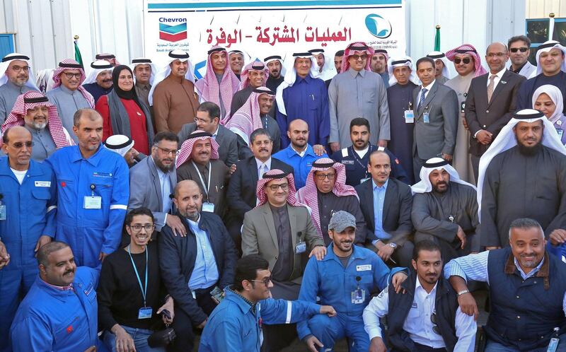 Kuwaiti Oil Minister Khaled Al Fadhel  and Prince Abdulaziz bin Salman pose for a group photo with employees of the Kuwait Gulf Oil Company and Saudi Arabian Chevron, during a ceremony marking the signing of an agreement to reproduce oil in the neutral zone between the two countries, at Wafra about 100 kilometres south of Kuwait City.   AFP