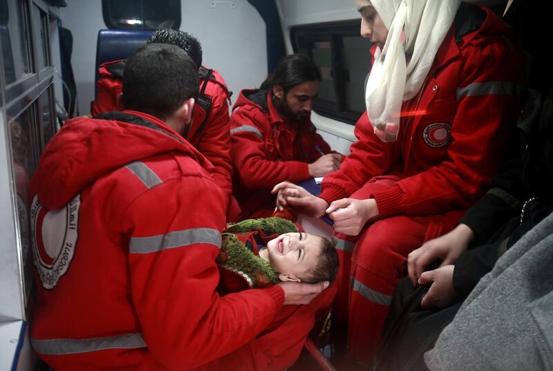 TOPSHOT - Syrian staff from the International Committee of the Red Cross evacuate a baby in Douma in the eastern Ghouta region on the outskirts of the capital Damascus on December 26, 2017. 
Aid workers have begun evacuating emergency medical cases from Syria's besieged rebel bastion of Eastern Ghouta, the International Committee of the Red Cross said, after months of waiting during which the UN said at least 16 people had died. Eastern Ghouta is one of the last remaining rebel strongholds in Syria and has been under a tight government siege since 2013, causing severe food and medical shortages for some 400,000 residents. / AFP PHOTO / ABDULMONAM EASSA