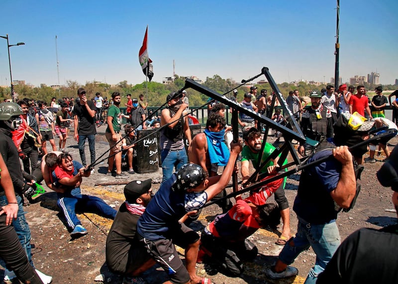 Anti-government protesters use a large slingshot to fire stones at security forces during clashes in Baghdad, Iraq. AP Photo