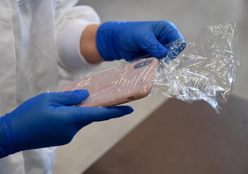 LAS VEGAS, NEVADA - SEPTEMBER 01: Senior student Angelica Eagle wraps her cell phone in clear plastic wrap to protect it from contamination before an in-person Phage Discovery Laboratory course by life sciences professor Dr. Christy Strong at UNLV amid the spread of the coronavirus (COVID-19) on September 1, 2020 in Las Vegas, Nevada. Strong has two other classes of 50 and 250 students that she teaches remotely. To lower the number of people on campus to allow for social distancing because of the pandemic, the university moved fall 2020 courses with more than 50 students, about 80 percent of its classes, to remote instruction, with 20 percent of courses held in-person or hybrid. UNLV is only using large classrooms with spaced out seating and under 50 percent capacity for in-person classes, which are now staggered to reduce density on the campus.   Ethan Miller/Getty Images/AFP
== FOR NEWSPAPERS, INTERNET, TELCOS & TELEVISION USE ONLY ==
