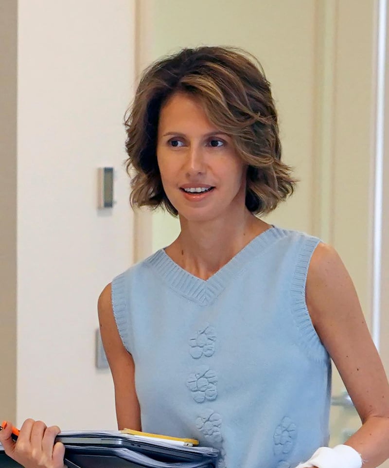 This handout picture released by the Syrian Presidency Facebook page on August 8, 2018, shows the Syrian First Lady Asma al-Assad carrying papers as she begins treatment for early-stage breast cancer at a hospital in the capital Damascus. (Photo by Handout / Syrian Presidency Facebook page / AFP) / RESTRICTED TO EDITORIAL USE - MANDATORY CREDIT "AFP PHOTO / Syrian Presidency Facebook page " - NO MARKETING NO ADVERTISING CAMPAIGNS - DISTRIBUTED AS A SERVICE TO CLIENTS