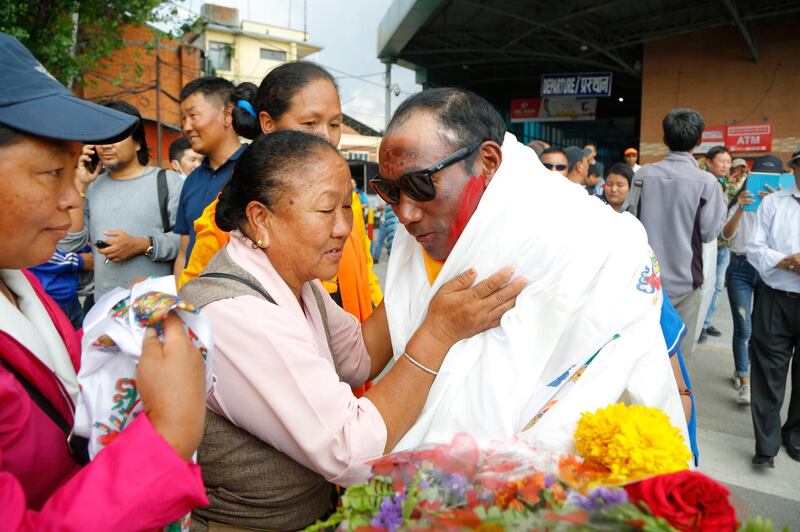 Kami Rita receives a ceremonial scarf from friends. Niranjan Shrestha / AP Photo