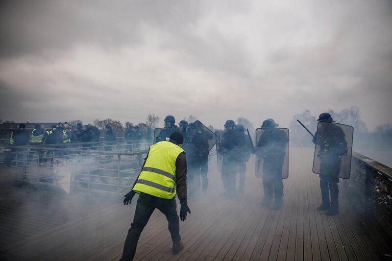Demonstrators clash with riot police officers in Paris, during an anti-government demonstration called by the yellow vest "Gilets Jaunes" movement.  AFP