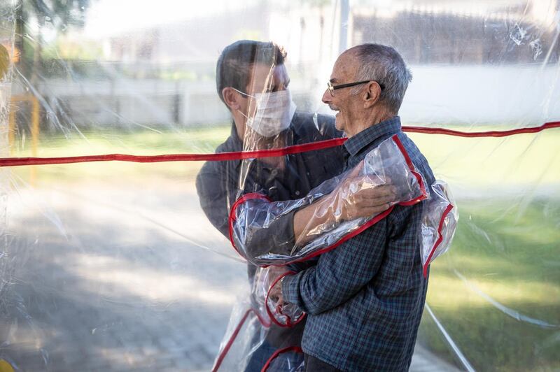 A son hugs his father at the Geriatric Clinic Três Figueiras in Gravatai, Brazil. The clinic created the Tunel do Abraco (hug tunnel) for elderly residents to be able to hug relatives after more than 70 days apart due to the coronavirus pandemic.  Getty