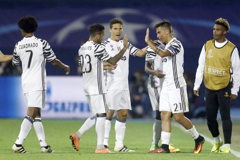 Juventus’ Paulo Dybala, right, celebrates after scoring his side’s third goal. Darko Bandic / AP Photo