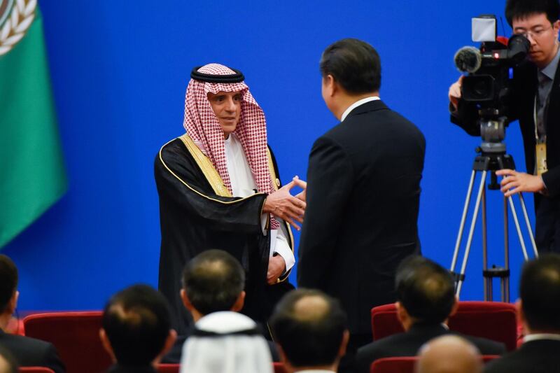 Mr. al-Jubeir shakes hands with Mr. Jinping after giving a speech. AFP