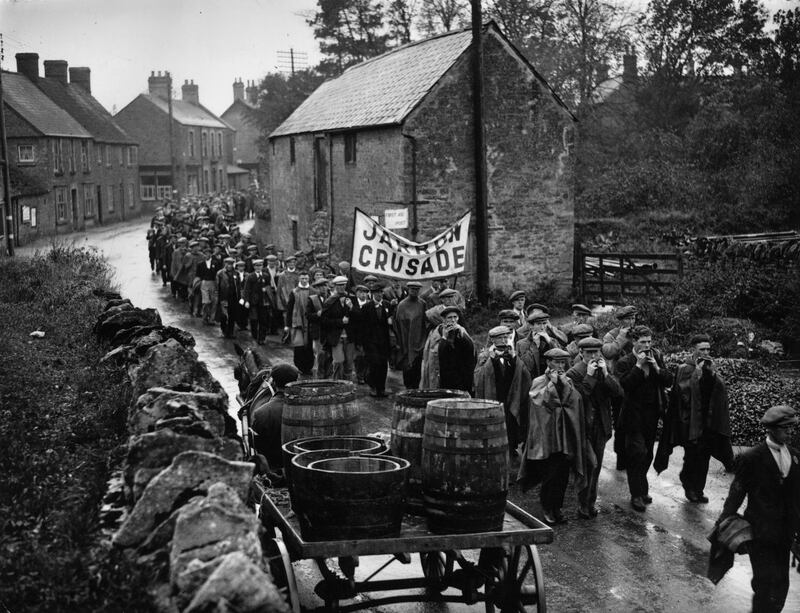 Jarrow marchers passing throught the village of Lavendon, near Bedford, on their way to London, many playing mouth organs to keep spirits up. The Jarrow March was a hunger march during the Great Depression, starting in Jarrow it reached London a month later to put pressure on the coalition government of Prime Minister Ramsay MacDonald.   (Photo by Savill/Getty Images)