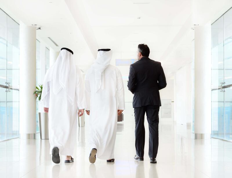 Three arab business men walking, meeting. Getty Images