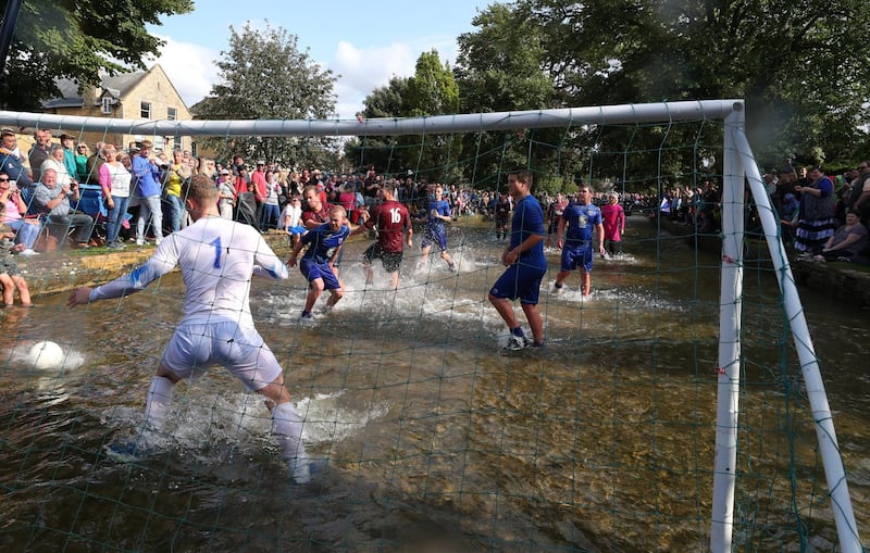 BOURTON-ON-THE-WATER, ENGLAND - AUGUST 27: Players from Bourton Rovers compete against each other  during the annual Bourton-on-the-Water Football Match played on the River Windrush on August 27, 2018 in Bourton-on-the-Water, England. (Photo by Catherine Ivill/Getty Images)