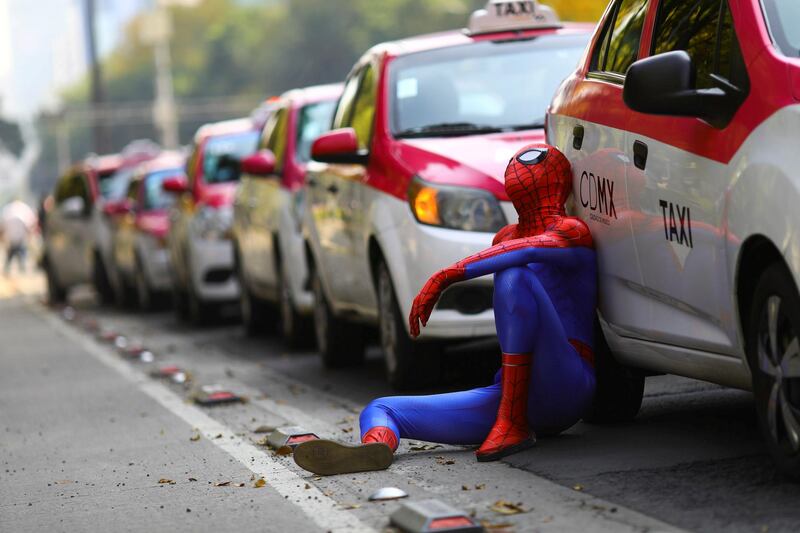 A person dressed up as Spider-Man sits next to the cabs as taxi drivers hold a protest against taxi-hailing apps such as Uber, Cabify and Didi at Angel de la Independencia monument, in Mexico City, Mexico. Reuters