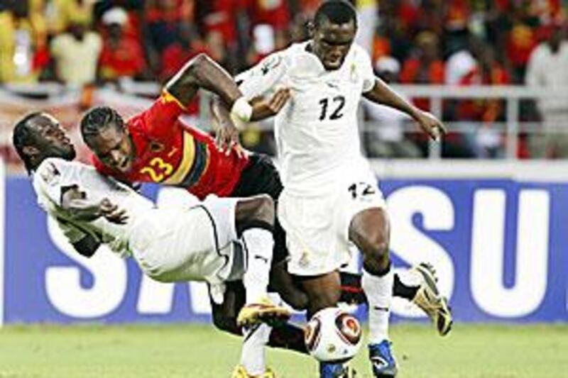 Angola's Manucho, centre, is sandwiched by two Ghana players on Sunday.