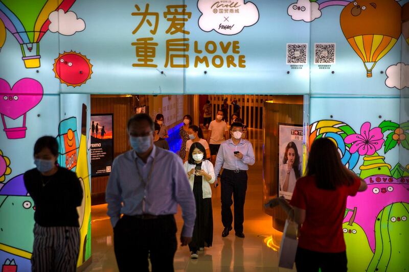 FILE - In this Aug. 14, 2020, file photo, people wearing face masks to protect against the coronavirus walk through a shopping mall in Beijing. Chinaâ€™s economic growth accelerated to 4.9% over a year earlier in the latest quarter as a shaky recovery from the coronavirus pandemic gathered strength. (AP Photo/Mark Schiefelbein, File)
