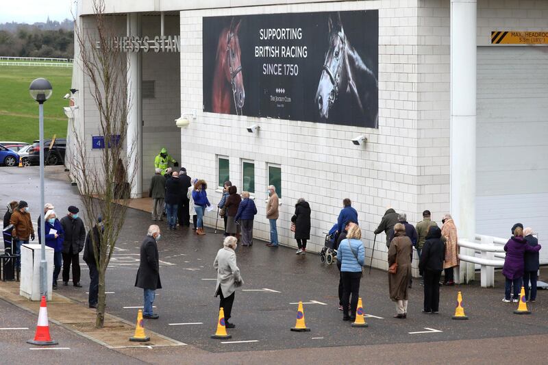 EPSOM, ENGLAND - JANUARY 11: Members of the public queue to receive the Oxford/AstraZeneca Covid-19 vaccine at the NHS vaccine centre that has been set up at Epsom Racecourse on January 11, 2021 in Epsom, England. The location is one of several mass vaccination centres in England to open to the public this week. The UK aims to vaccinate 15 million people by mid-February. (Photo by Dan Kitwood/Getty Images)