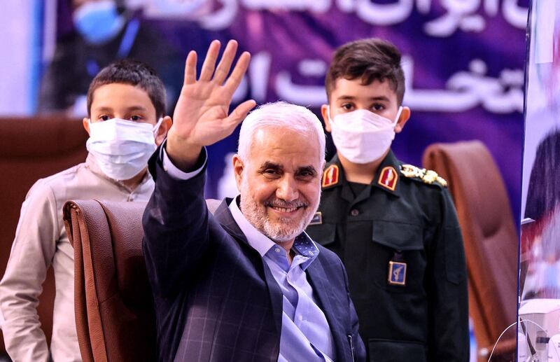 Former Iranian vice president Mohsen Mehralizadeh, accompanied by his grandsons, salutes supporters as he registers his candidacy at the Interior Ministry in the capital Tehran on May 13, 2021, for the Islamic Republic's upcoming presidential elections. Registration for the June 18 poll runs till the end of this week, after which names will be handed to the conservative-dominated Guardian Council for vetting. / AFP / ATTA KENARE
