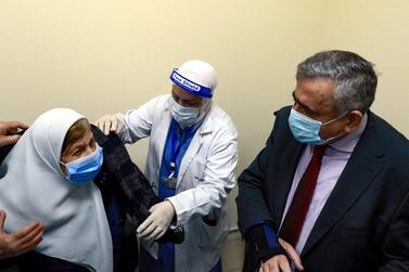 Jordanian Minister of Health Nazir Obeidat watches as a woman prepares to receive a dose of vaccine against the coronavirus disease at a hospital in Amman, Jordan. AFP 