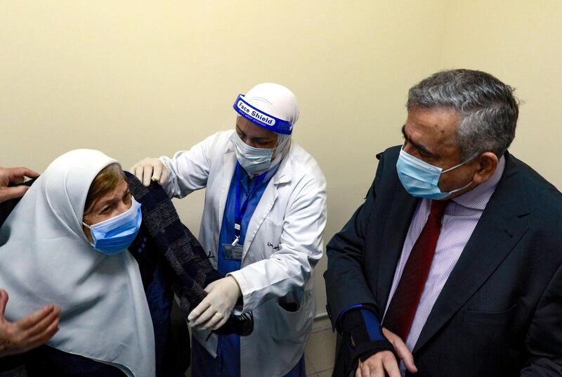 Jordanian Minister of Health Natheer Obeidat (R) looks on as a woman prepares to receive a dose of vaccine against the coronavirus COVID-19 disease, at a hospital in the capital Amman, on January 13, 2020.  Jordan had approved the Sinopharm vaccine for emergency use, after giving the Pfizer-BioNTech jab the green light.
The Hashemite kingdom has officially registered more than 305,000 novel coronavirus cases and nearly 4,000 deaths.
 / AFP / Khalil MAZRAAWI
