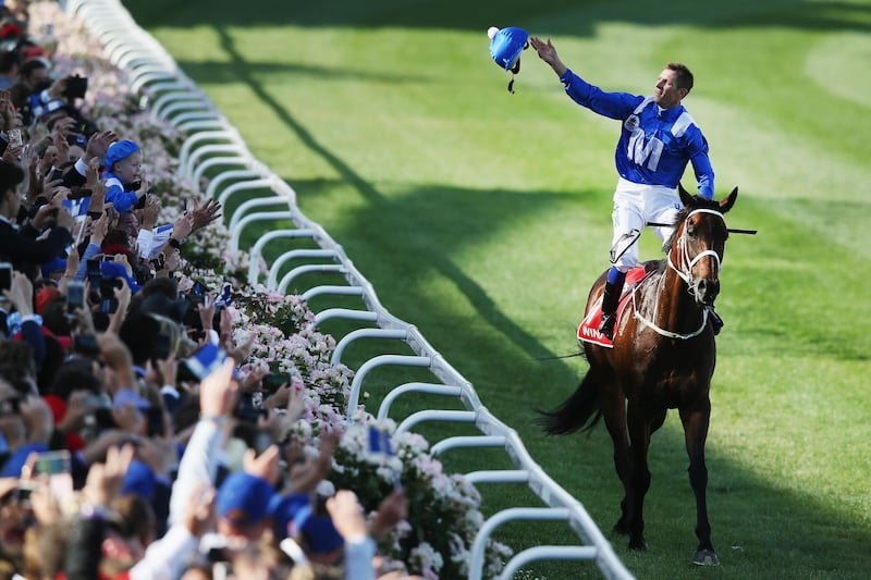 Hugh Bowman throws his helmet into the crowd on returning to scale after winning on Winx to win race 9 the Ladbrokes Cox Plate during Cox Plate Day at Moonee Valley Racecourse. Michael Dodge / Getty Images