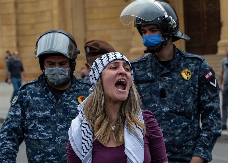 Anti-government protestor shouts slogans in front Lebanese police officers as they try to close the road in front Al-Ameen mosque during a protest against the collapsing Lebanese pound currency and the price hikes of goods, in downtown Beirut, Lebanon.  EPA