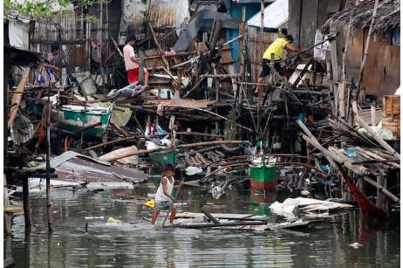 Residents recover belongings from their destroyed shanty homes, which were lashed by Typhoon Conson in Las Pinas, south of Manila on Wednesday, July 14, 2010.