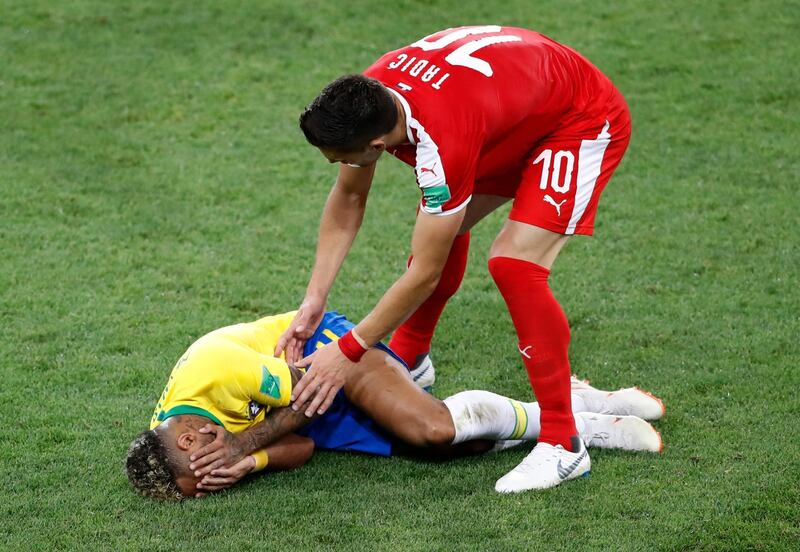 Serbia's Dusan Tadic checks on the condition of Neymar. Antonio Calanni / AP Photo