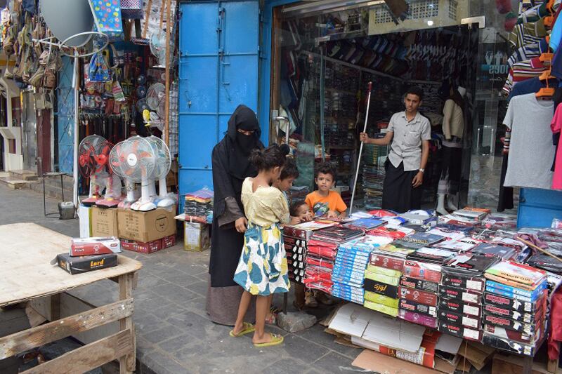 A woman shops for clothes for her children in a public market in Crater district in Aden, Yemen, a few days before Eid Al Adha. Ali Mahmood