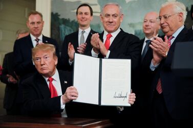 US President Donald Trump holds up his proclamation recognising Israel's sovereignty over the Golan Heights as Israeli Prime Minister Benjamin Netanyahu applauds. Reuters