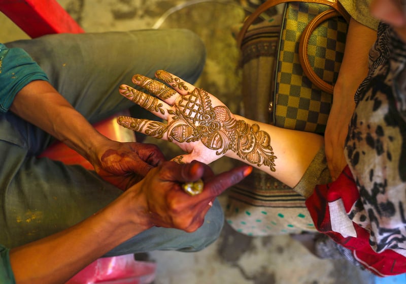 A Kashmiri Muslim girl decorates her hands with henna at a market in Srinagar. EPA