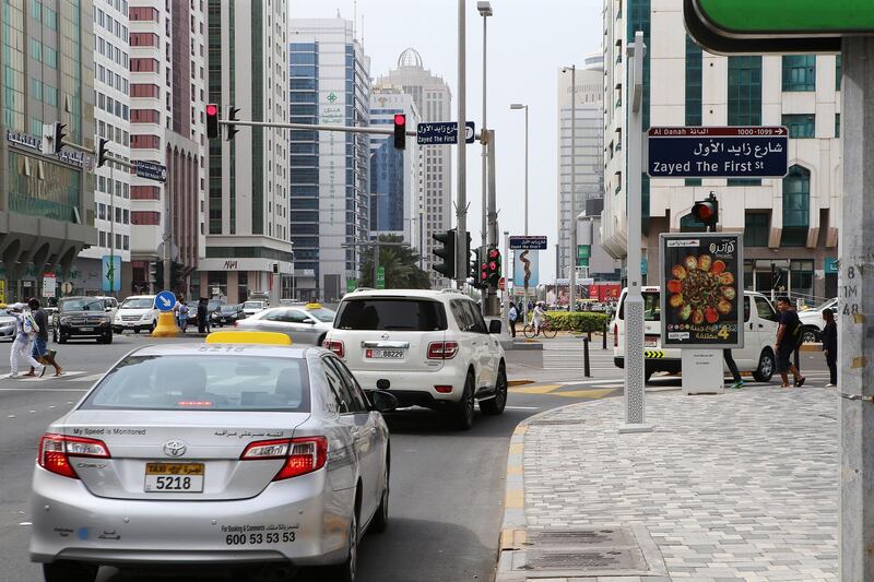 ABU DHABI - UNITED ARAB EMIRATES - 30MAR2016 - An advertisement board on the junction of Fatima bint Mubarak (Najda) Street and Zayed the First (Electra) Street, which is positioned right next to an amber light post and a pedestrian sign (pedestrian ahead). The board is blocking the view of a driver as he or she turns right to a pedestrian crossing towards Zayed The First Street in Abu Dhabi. Ravindranath K / The National (to go with Ramona story for News)
ID: 23567
 *** Local Caption ***  RK3003-roadsigns02.jpg