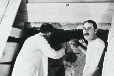 Howard Carter, right, opening the door to the tomb of Tutankhamun in 1922. Getty