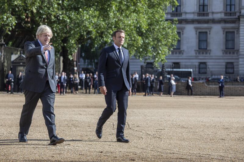 British Prime Minister Boris Johnson and French President Emmanuel Macron in Horseguards parade ground to watch the Red Arrows and La Patrouille de France fly over in London. Getty Images