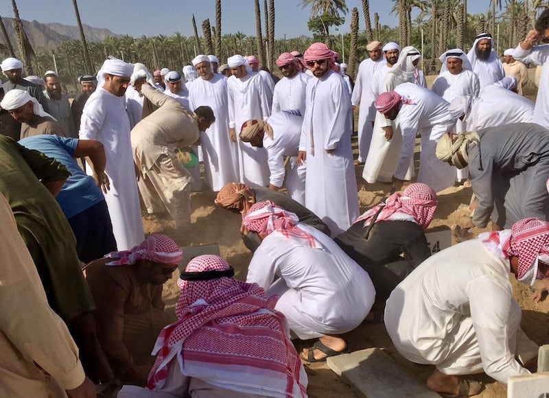 People attend the funeral for the children who died in a house fire in Fujairah. Pawan Singh / The National