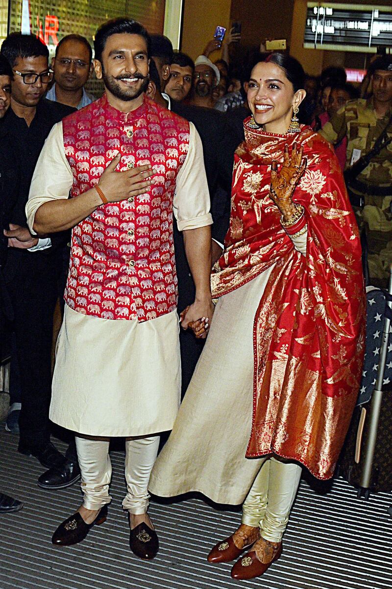 Bollywood actors and recently-wedded couple Ranveer Singh (L) and Deepika Padukone acknowledge fans gathered at the Mumbai international airport early on November 18, 2018, following their return from their nuptials at Italy's Lake Como.  Photo / AFP