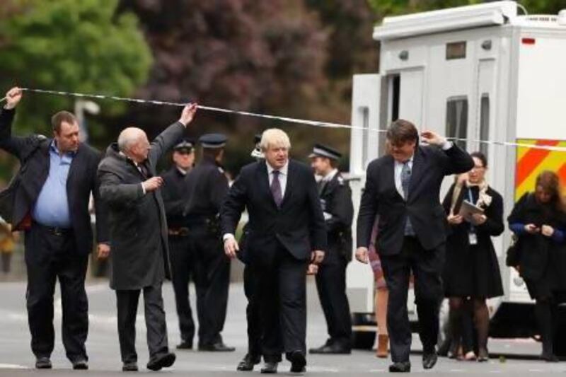 London mayor Boris Johnson (centre) walks under police tape near the scene of the killing of a British soldier in Woolwich.