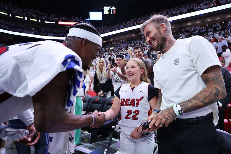 Jimmy Butler of the Miami Heat greets Beckham and his daughter, Harper, at a game in Miami, Florida. AFP
