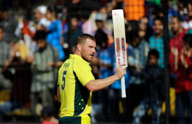 Australia cricket player Aaron Finch shows his bat on his way to the pavilion after scoring hundred during the third one-day international cricket match between India and Australia in Indore, India, Sunday, Sept. 24, 2017. (AP Photo/Rajanish Kakade)