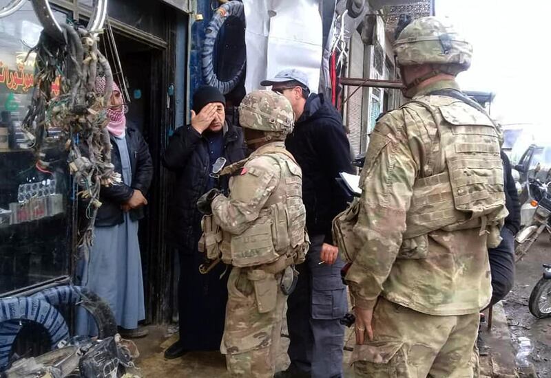 This photo released on the Facebook page of the Military Council of Manbij City, shows U.S. troops based around the Syrian town of Manbij speaking with residents, in northern Syria, Sunday, Dec. 23, 2018. (The Military Council of Manbij City via AP)