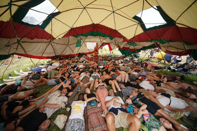 Festivalgoers take part in a laughter-yoga workshop in the Healing Field.  PA