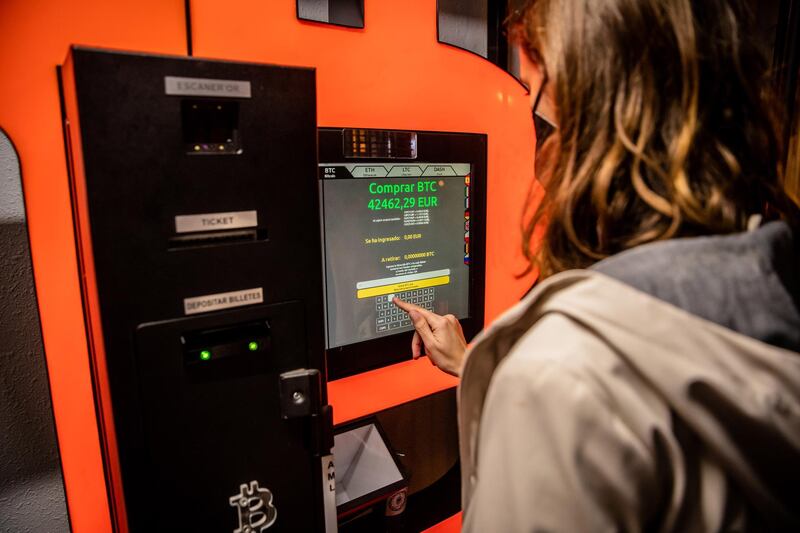 A customer uses a bitcoin automated teller machine (ATM) in a kiosk Barcelona, Spain, on Tuesday, Feb. 23, 2021. Bitcoin climbed, aided by supportive comments from Ark Investment Management’s Cathie Wood and news that Square Inc. boosted its stake in the cryptocurrency. Photographer: Angel Garcia/Bloomberg