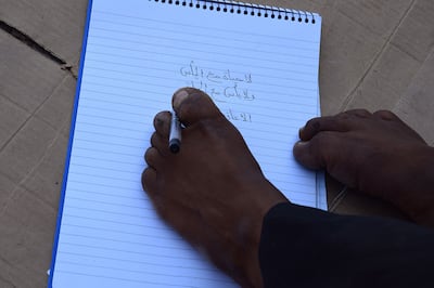 Khalil manages to write an Arabic quote using his toes. Ali Mahmood for The National