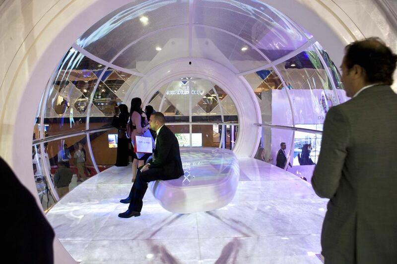 Visitor sit on a mock-up of a Bluewater ferris wheel capsule. Razan Alzayani / The National