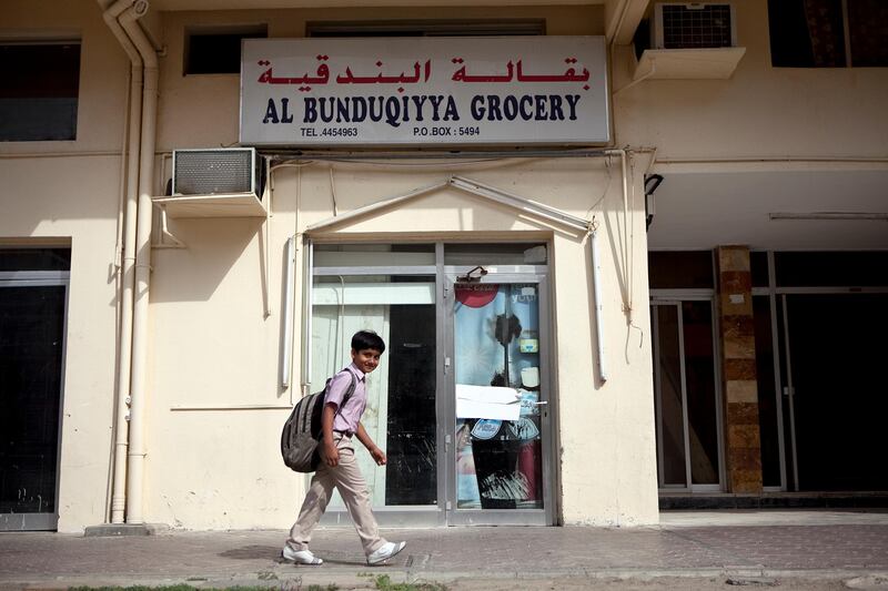 Abu Dhabi, United Arab Emirates, January 10, 2013: 
A school boy walks by the Al Bunduqiyya Grocery, a recently closed convenience store on Thursday, Jan. 10, 2013, in the city block between Airport and Muroor, and Delma and Mohamed Bin Khalifa streets in Abu Dhabi. 
Silvia Razgova/The National

