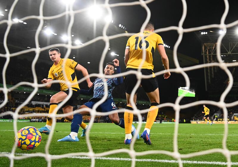 WOLVERHAMPTON, ENGLAND - FEBRUARY 10: Gabriel Magalhaes of Arsenal scores their team's first goal past Leander Dendoncker and Conor Coady of Wolverhampton Wanderers during the Premier League match between Wolverhampton Wanderers and Arsenal at Molineux on February 10, 2022 in Wolverhampton, England. (Photo by Clive Mason / Getty Images)
